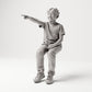 Sitzende Figur: Junge in T-Shirt & Hose mit ausgestrecktem Zeigefinger (B006) - Vorderansicht