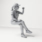 Diorama modelbouw productfoto 3: Zittende figuur: toeschouwster met gekruiste benen en geheven vuist (B057)