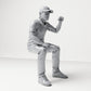 Diorama modelbouw productfoto 3: Zittende figuur: Mannelijke toeschouwer met opgeheven gebalde vuist (B065)