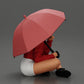 Diorama modelbouw productfoto 1: Diorama-miniatuur: Zittende vrouw in jas en shorts met open paraplu (Ref Nr. A85)